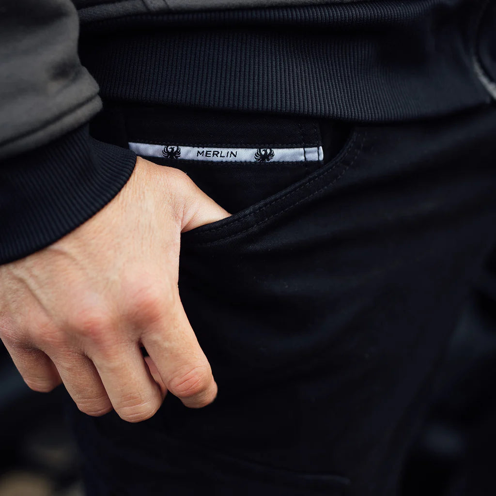 close up of Person holding pocket of black Merlin Remy CE UKCA AA rated protective motorcycle trousers